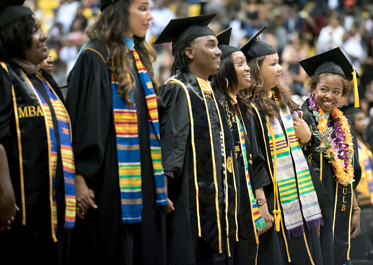 Six Black Cal State Long Beach students at graduation wearing their cap and gown.
