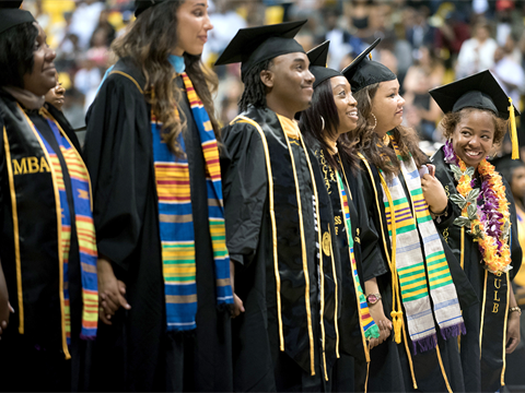 Six Black Cal State Long Beach students at graduation wearing their cap and gown.