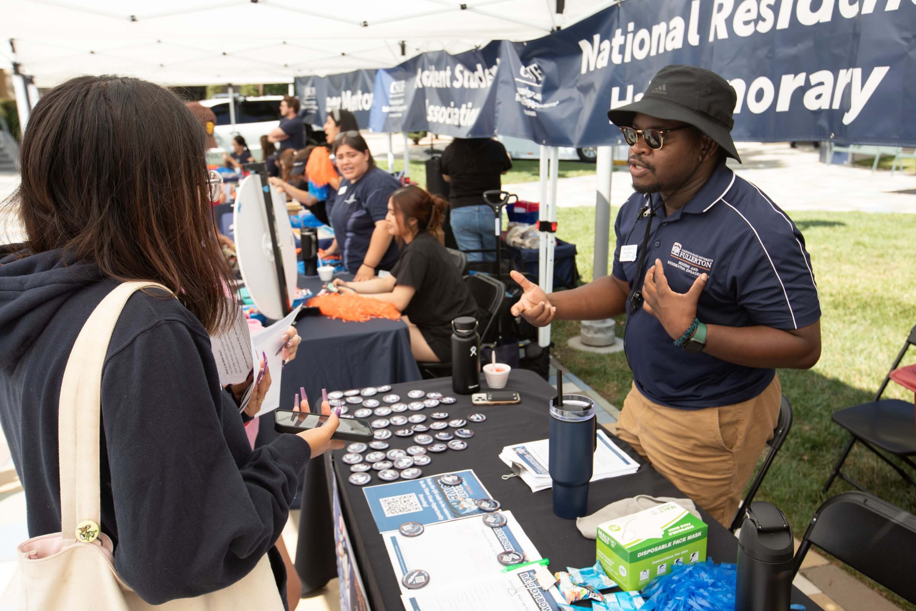 people talking at an outdoor booth