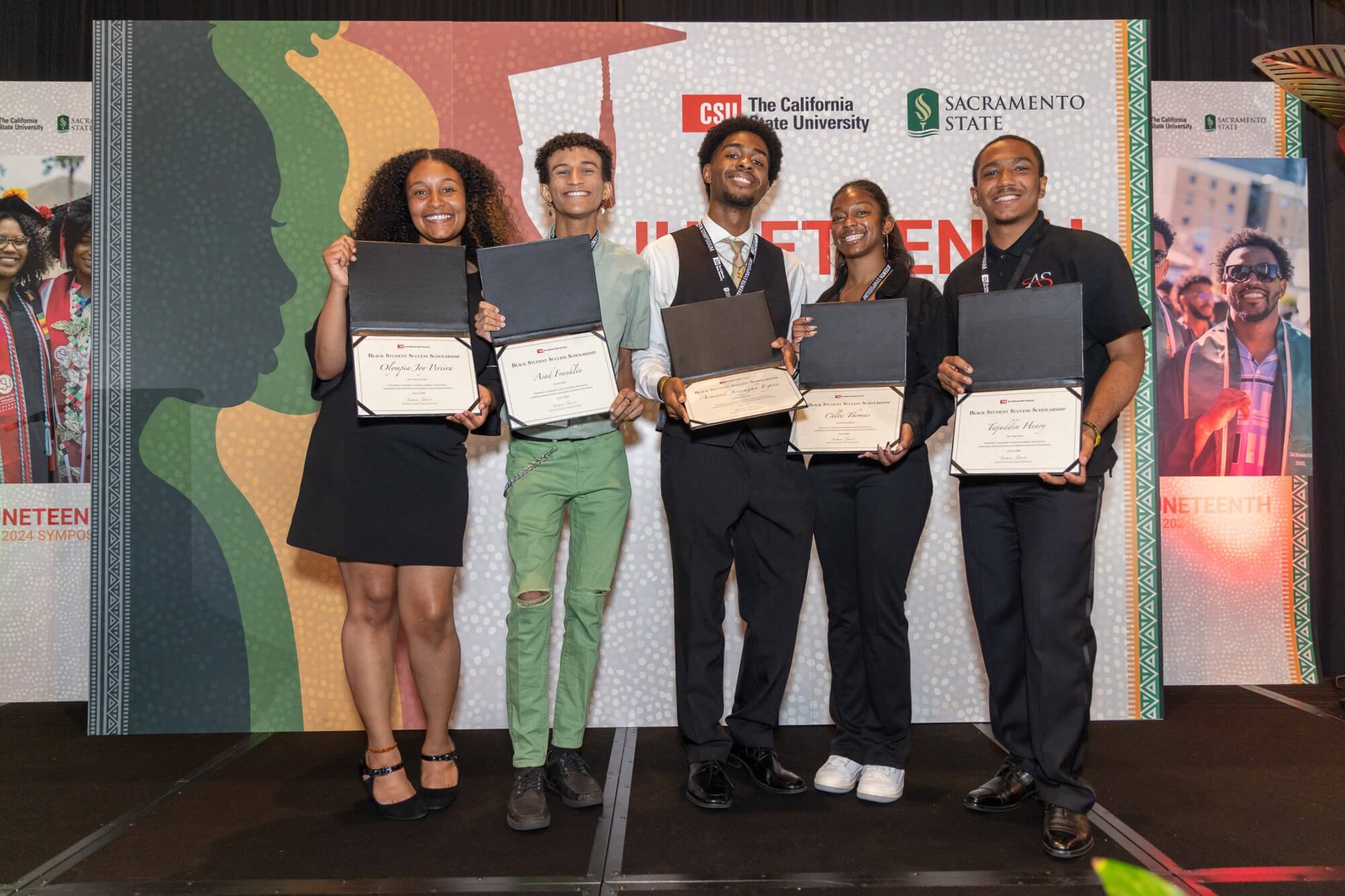 black student success scholarship winners holding up their awards
