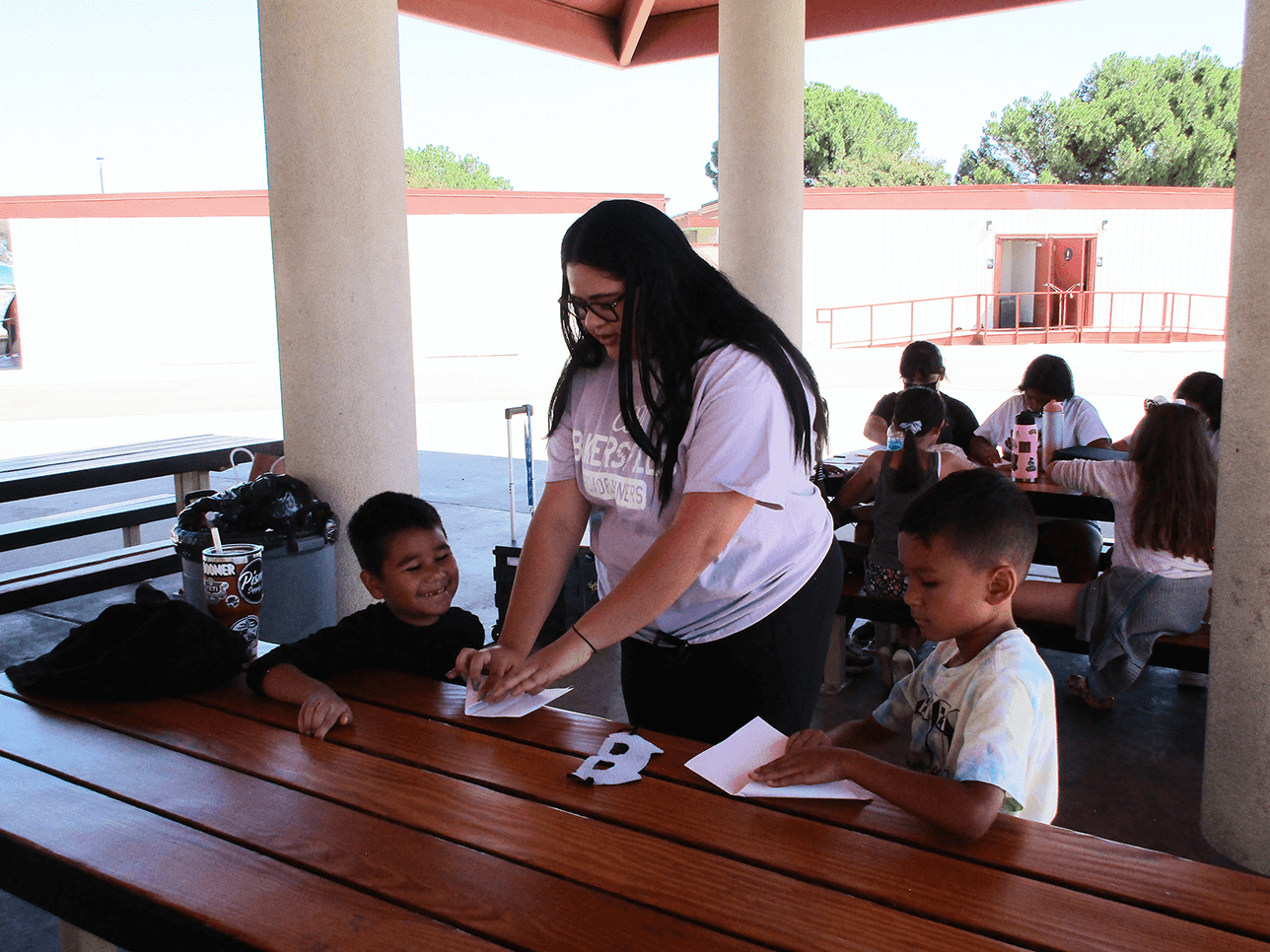 a college student helping two children with homework