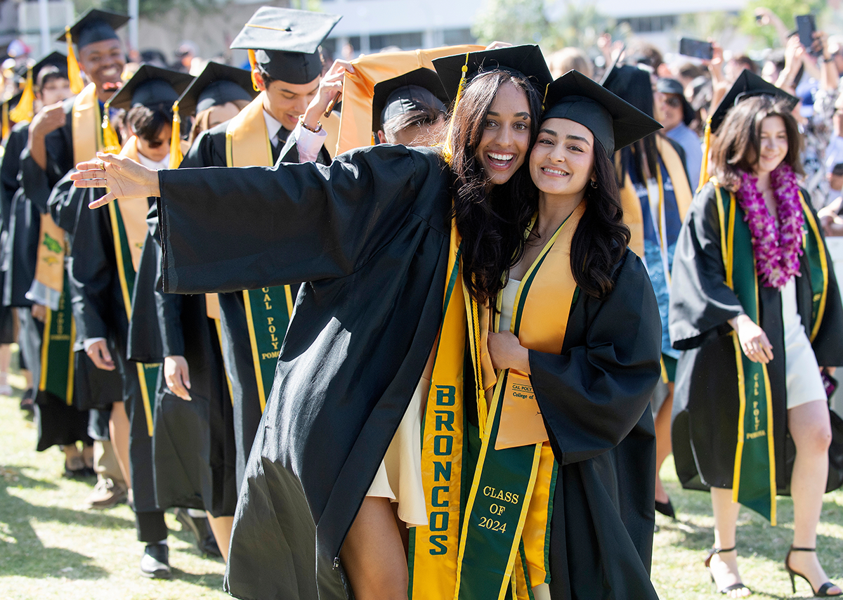 Two female Cal Poly Pomona students posing for a picture at graduation.