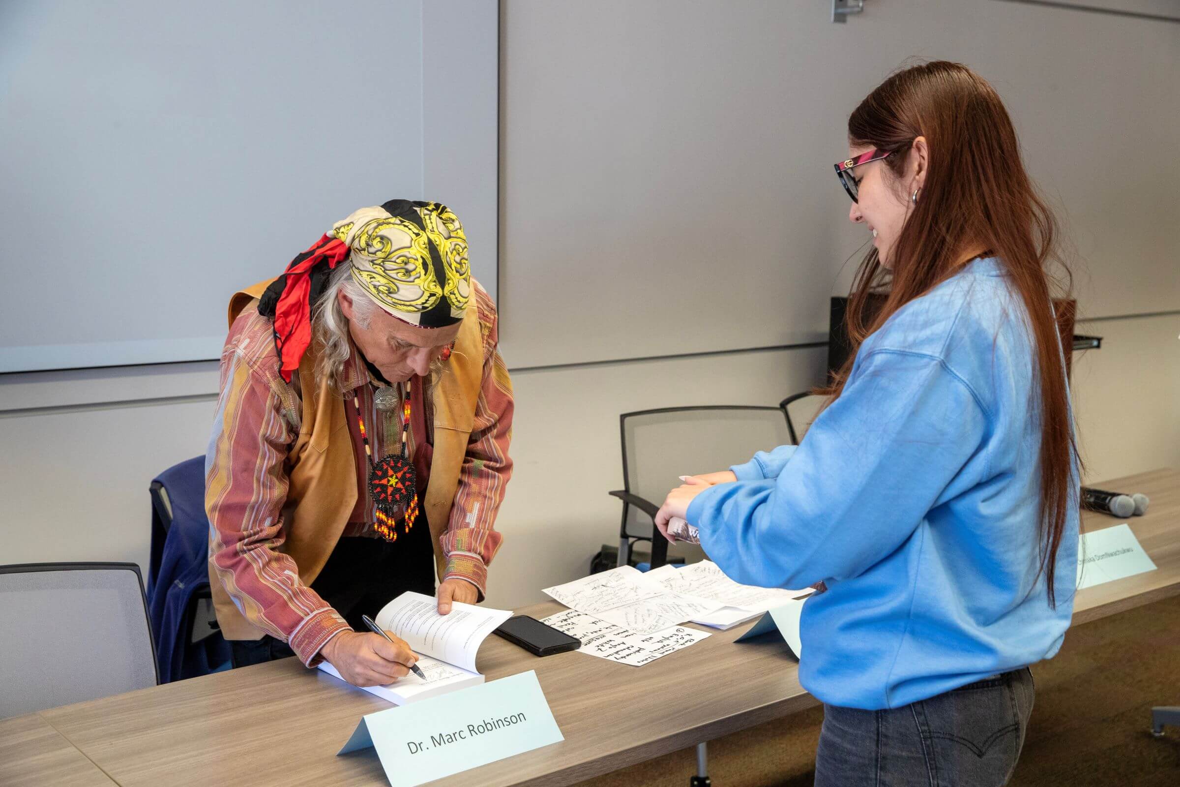 CSUSB Professor James Fenelon signs a copy of his book