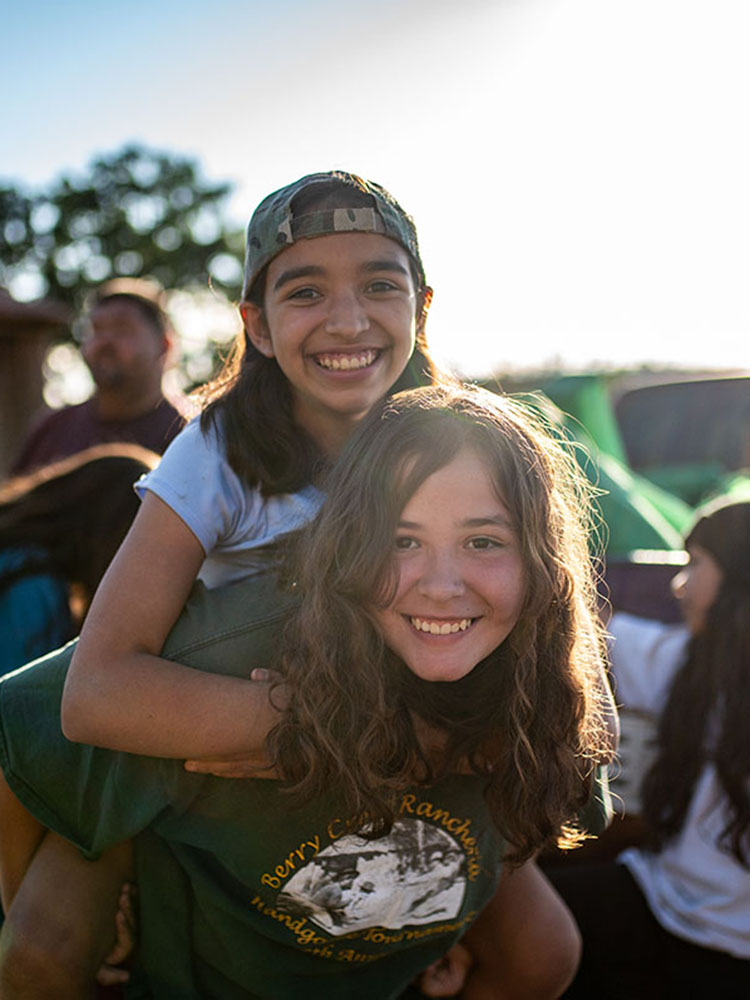 A girl gives another a piggyback