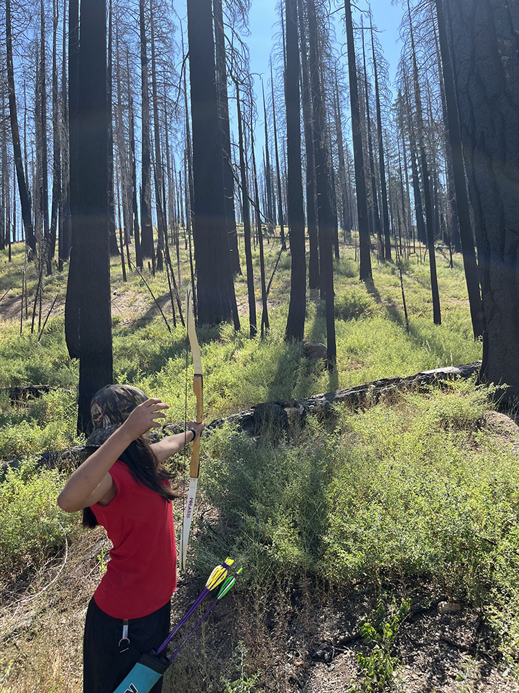 A student shoots a bow and arrow