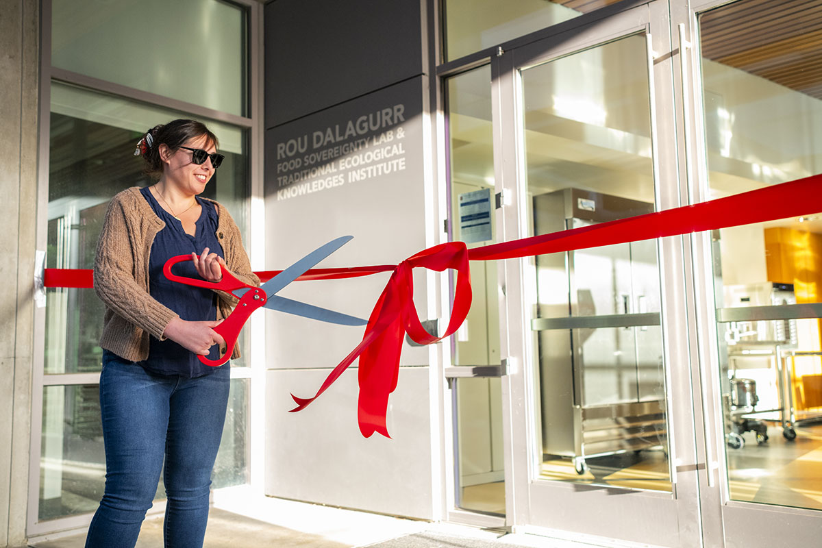 Kaitlin Reed cuts a ribbon in front of the lab