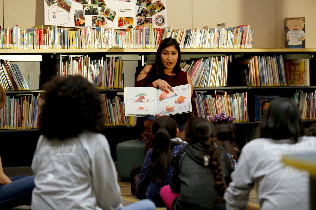 woman reads in library to children