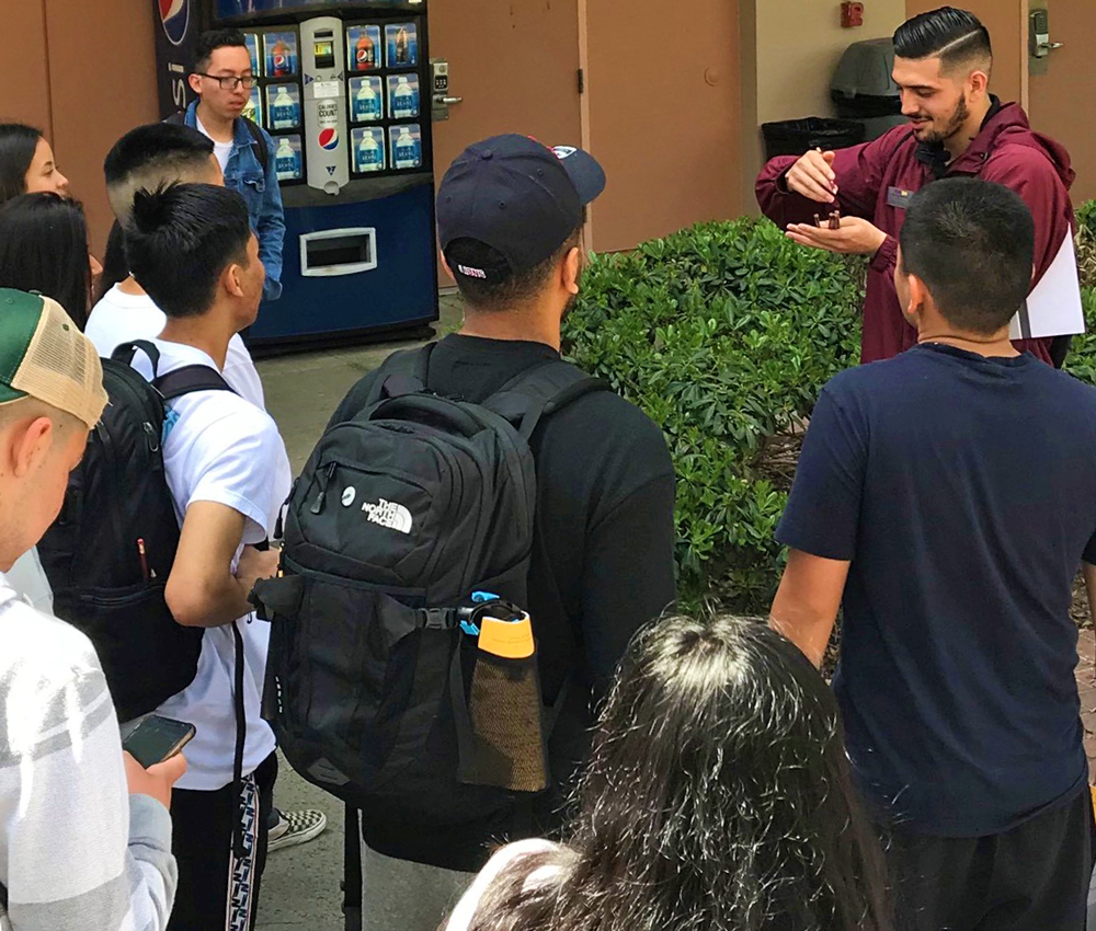 Anthony performs an ice breaker game for new students during a campus tour.